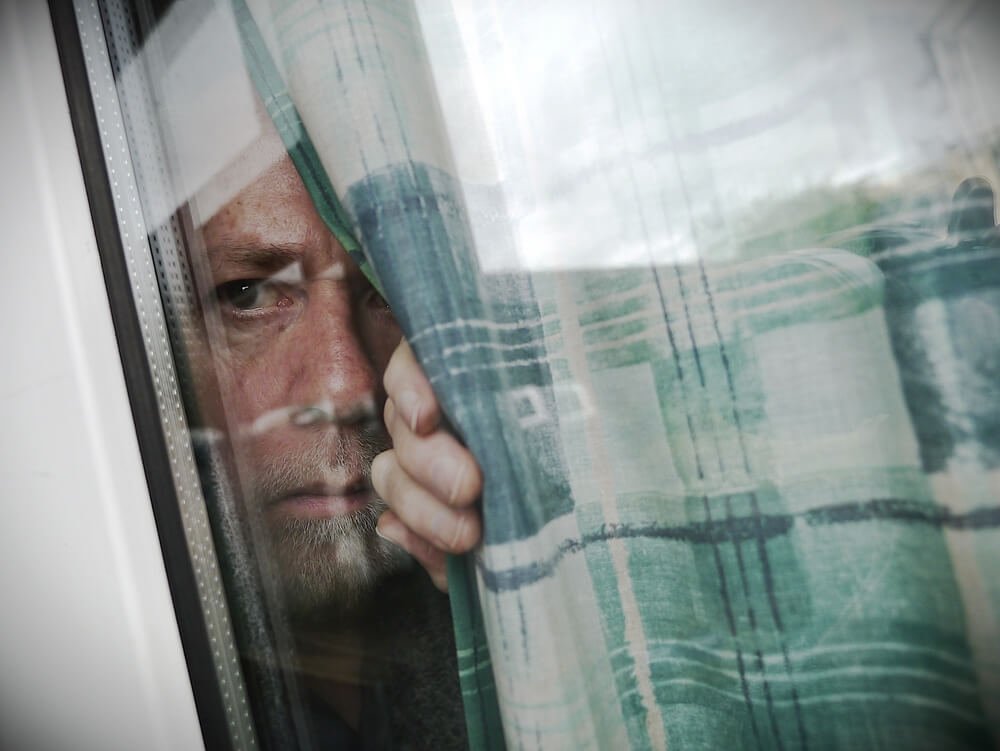 Man hiding behind window