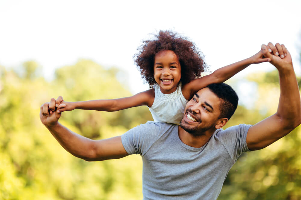 Father carrying daughter on his back
