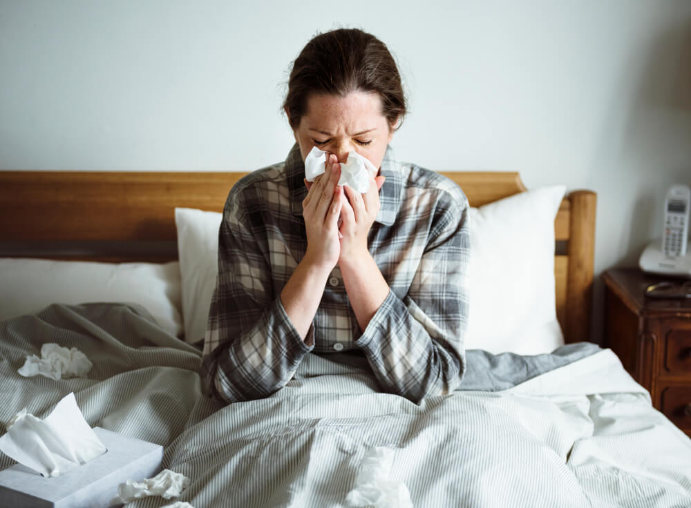 A woman suffering from flu in bed